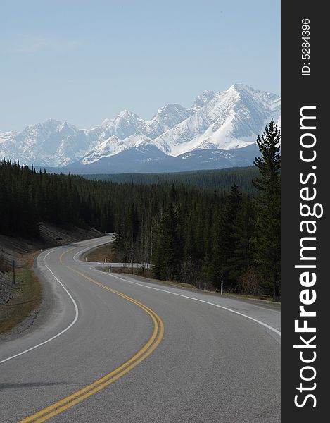 View of snow mountain and winding highway in kananaskis county, alberta, canada