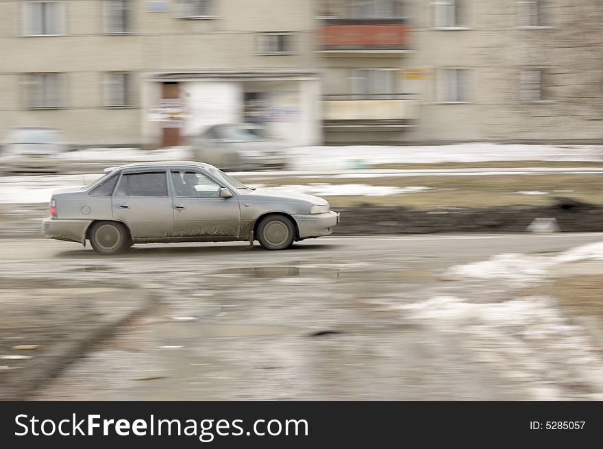 Photo of a car moving on a mud street. Photo of a car moving on a mud street