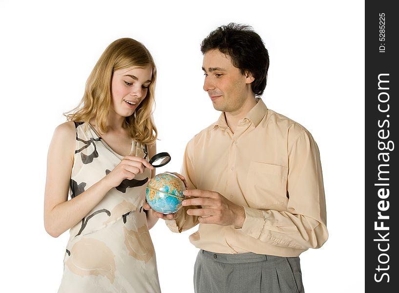A couple looking at a small globe through a magnifier. A couple looking at a small globe through a magnifier
