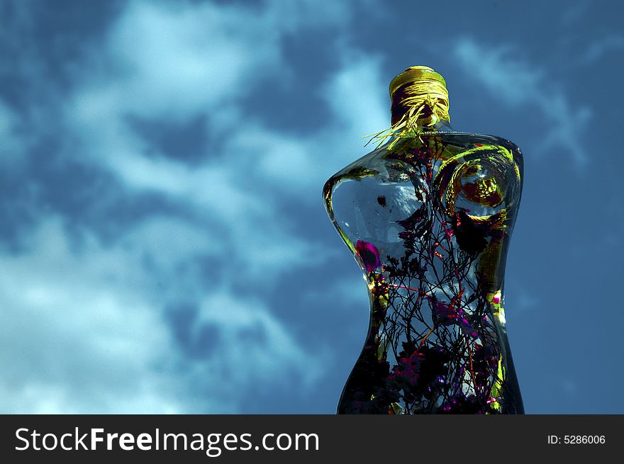 Glass woman with flowers on a background of sky. Glass woman with flowers on a background of sky