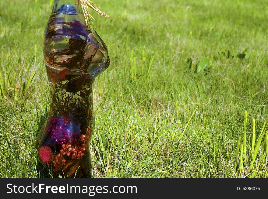 Glass woman with flowers on a background of green grass. Glass woman with flowers on a background of green grass