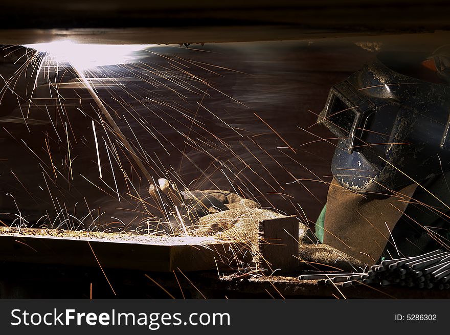 A welder working at shipyard during night shift. A welder working at shipyard during night shift