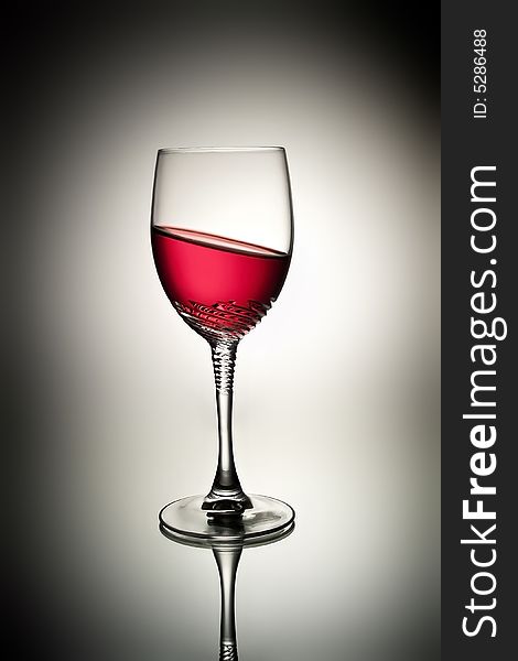 Glass with tilted red wine and reflection. Glass with tilted red wine and reflection