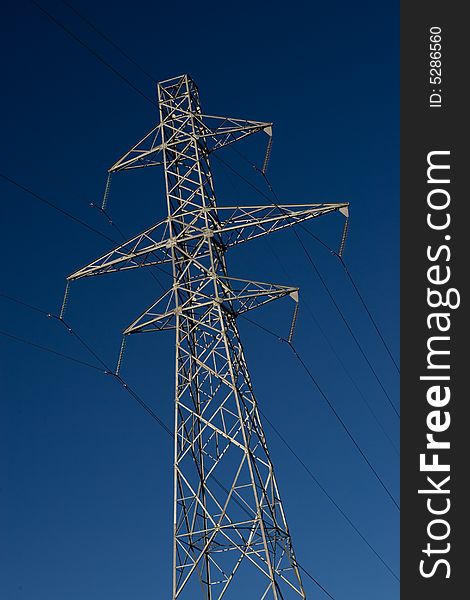 Power pylons with a dark blue sky