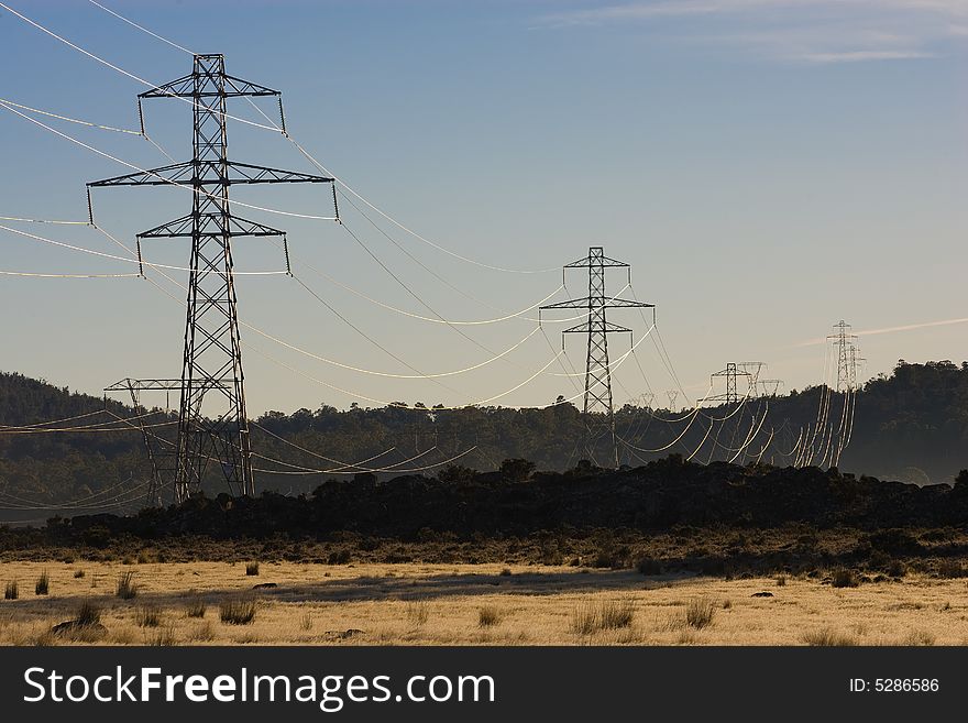 Power pylons crossing dry farmland