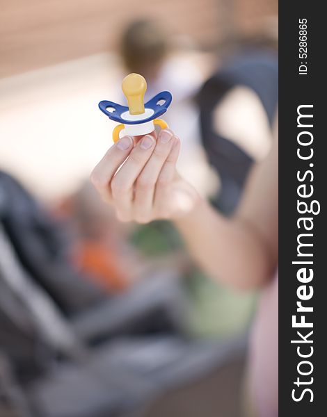 Woman holding blue binky in hand. Woman holding blue binky in hand