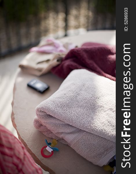 Towels, clothing, cellphone, and other objects on stone table