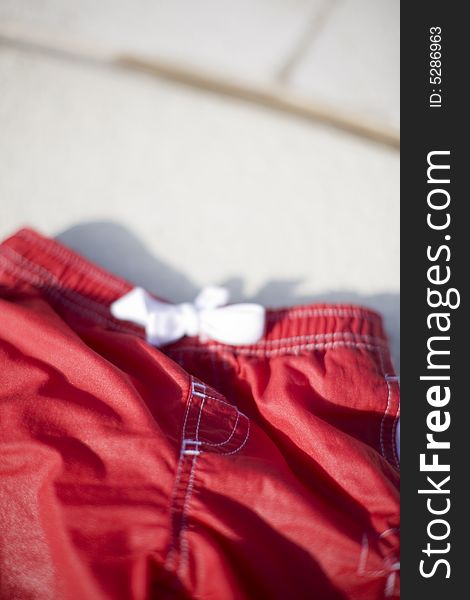 Small red shorts with white knot with tan background