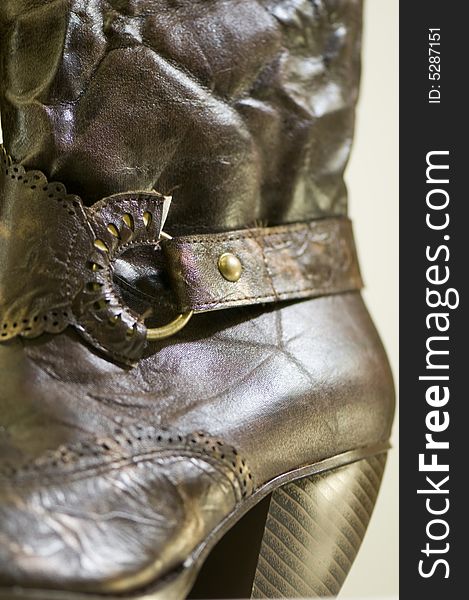 A pair of ladies boots manufactured from synthetic 'leather' with buckle and midi heel. The texture of the fabric can be seen. A pair of ladies boots manufactured from synthetic 'leather' with buckle and midi heel. The texture of the fabric can be seen.