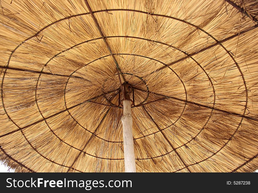 Brown rounded straw sun umbrella. Brown rounded straw sun umbrella