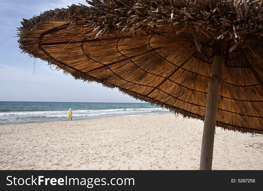 Straw parasol on the sandy beach. Straw parasol on the sandy beach