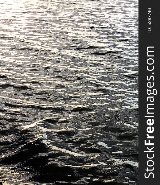 Bright golden sea wave ripples forming a wavy pattern. Bright golden sea wave ripples forming a wavy pattern.