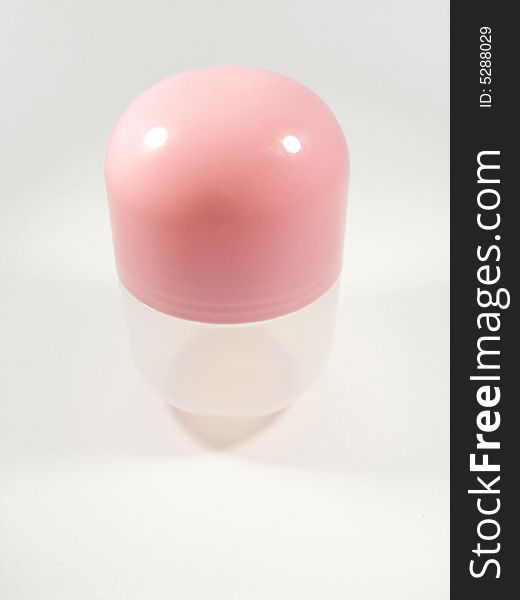 Big pink pill, isolated on a pink-ish/white-ish background.