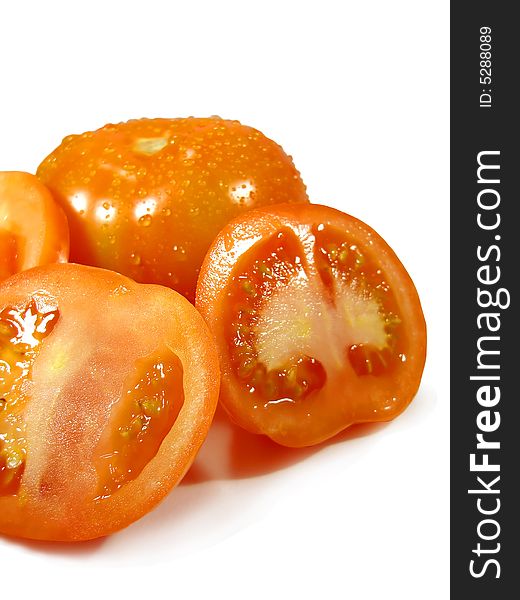 Bunch of tomatoes isolated on a white background, sliced and with droplets of water.