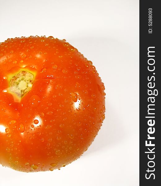 Isolated tomatoe on a white background with droplets of water. Isolated tomatoe on a white background with droplets of water.