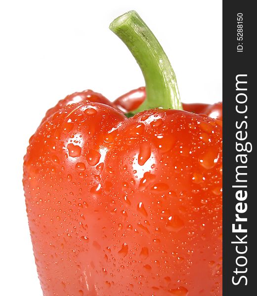 Side view detail on a red pepper bell vegetable with drops of water isolated on a white background. Side view detail on a red pepper bell vegetable with drops of water isolated on a white background.