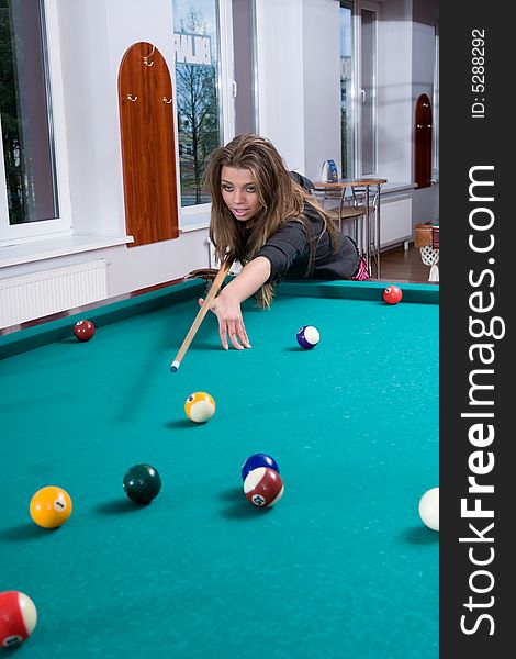 Young girl in short skirt playing snooker