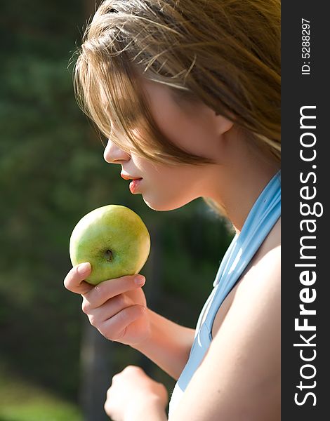 Girl with apple on sunset