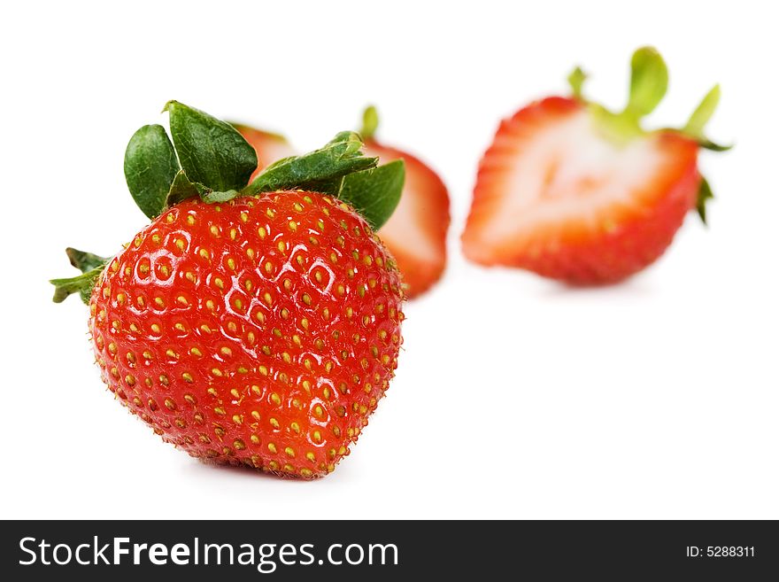 A strawberry with cut one in the background. A strawberry with cut one in the background