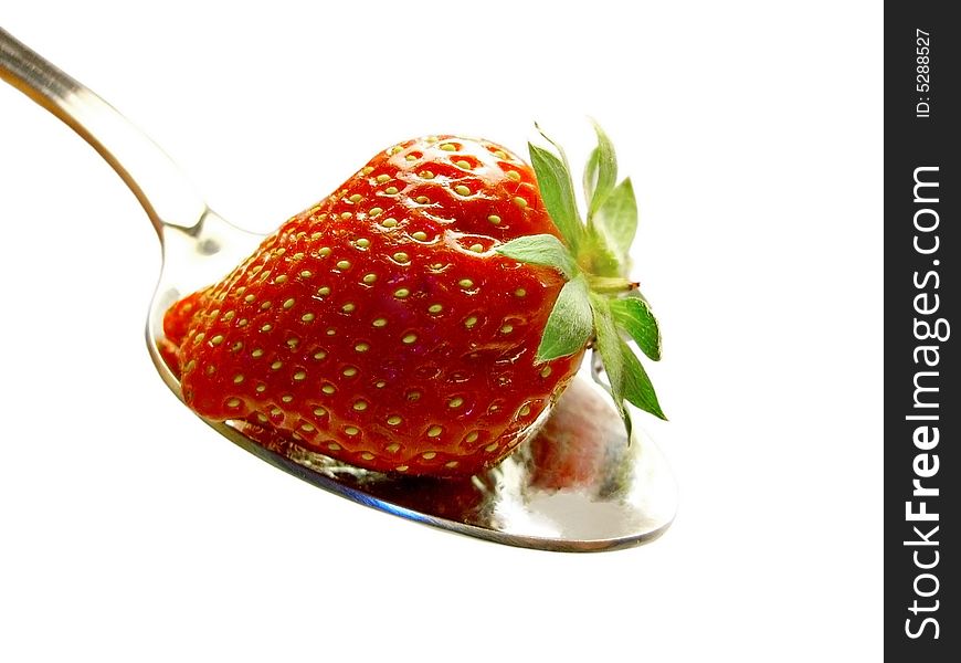 Strawberry with leafs on a spoon on a white background. Strawberry with leafs on a spoon on a white background.