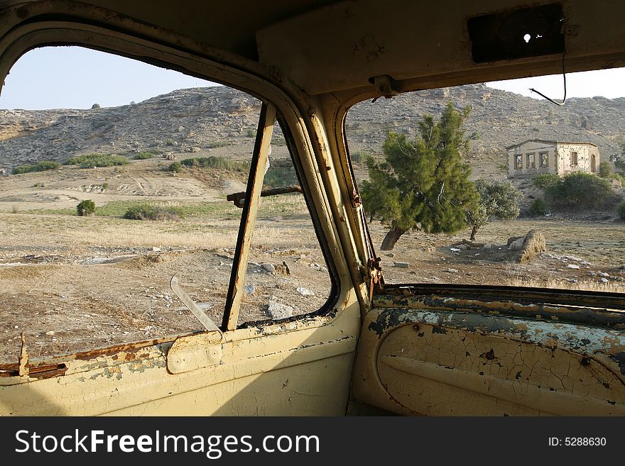 An old wreckage military car in a field. An old wreckage military car in a field