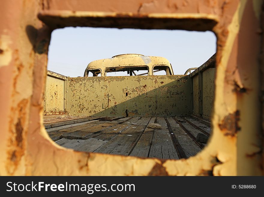An old wreckage military car in a field. An old wreckage military car in a field