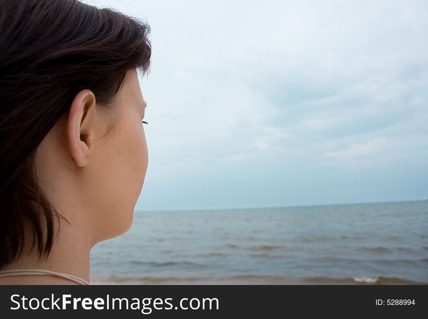 Girl on the beach looking at sea