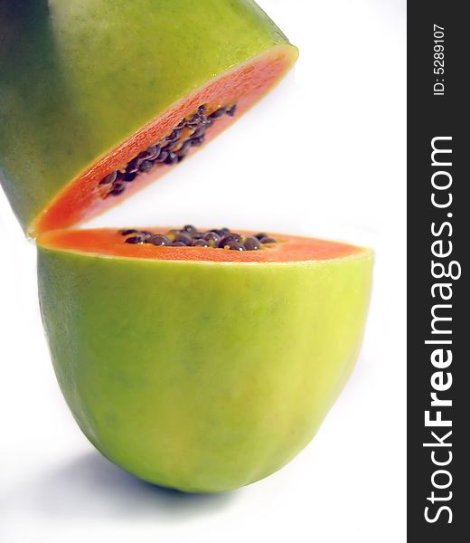 Vertical position of a papaya sliced on half isolated on a white background.