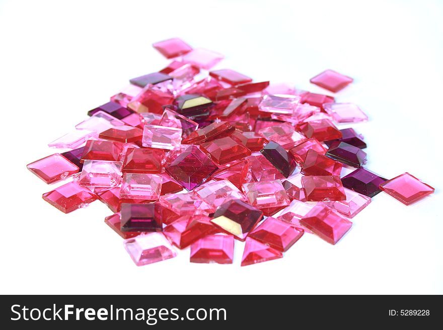 Pink plastic square bits on white background