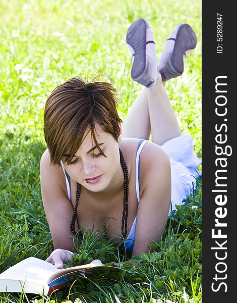 Beautiful blond woman reading over the grass. Beautiful blond woman reading over the grass.