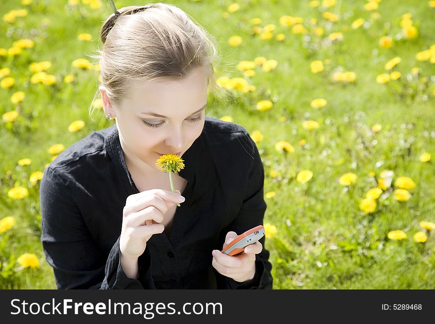 Phone And Flower. Young Woman On The Meadow.