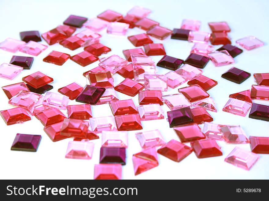 Pink plastic square bits on white background