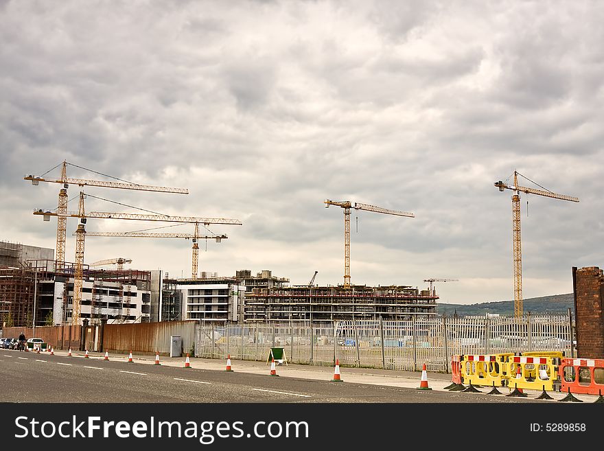 Busy construction site with cranes seen from afar. Busy construction site with cranes seen from afar