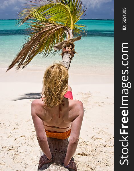 Girl and palm tree on the Bavaro Beach, Dominican republic