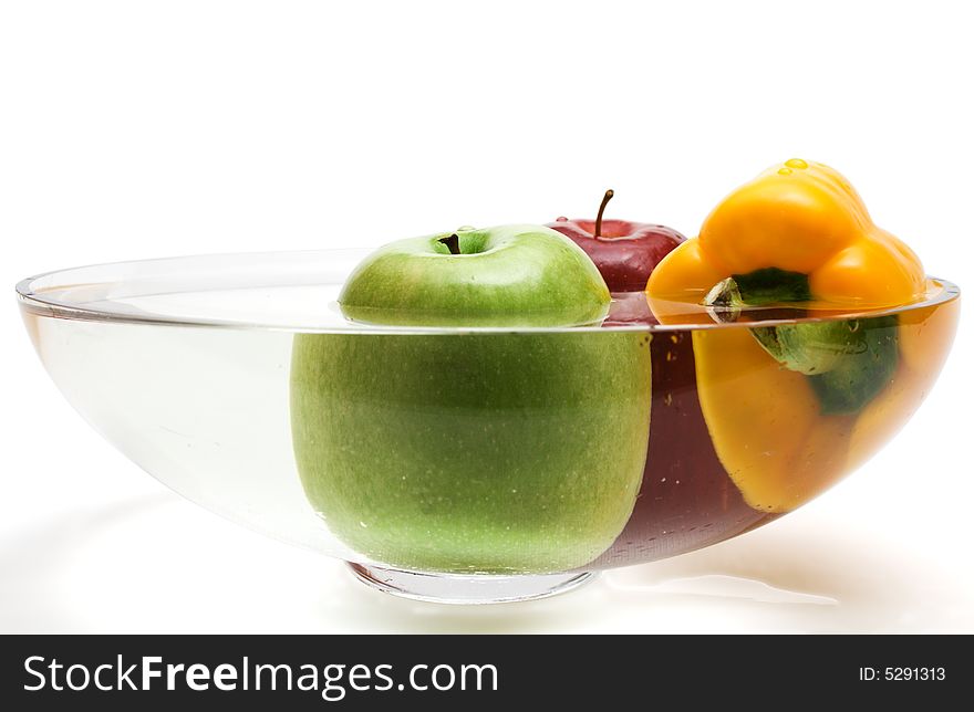 Green and red apples and yellow paprika in vase wi