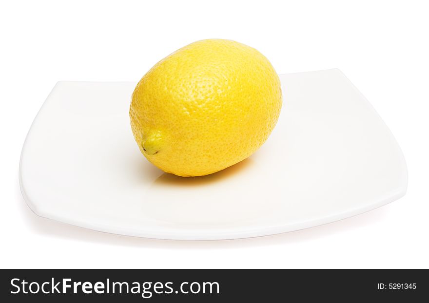 Yellow lemon on white ceramic plate, isolated, with clipping path