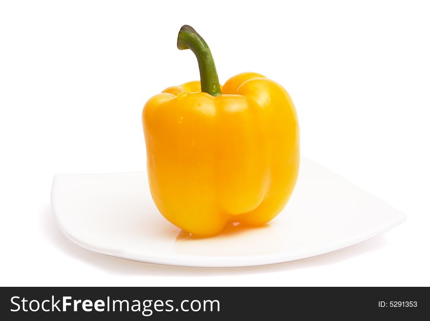 Yellow paprika on white ceramic plate, isolated, with clipping path