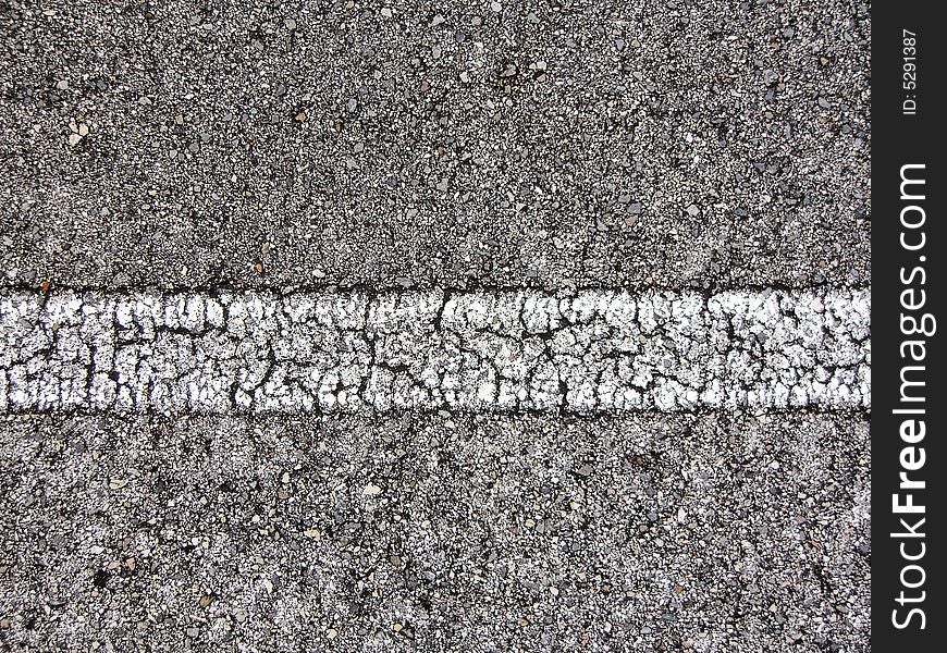 Straight white line view of an asphalt road with many cracks. Straight white line view of an asphalt road with many cracks.