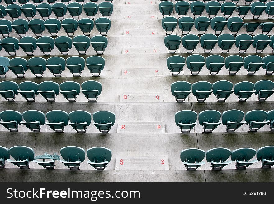 Empty Seating at Sports Stadium with Green Chairs