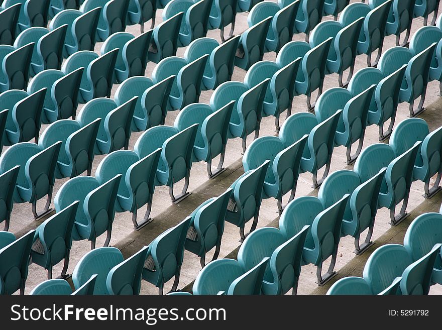 Empty Seating at Sports Stadium with Green Chairs