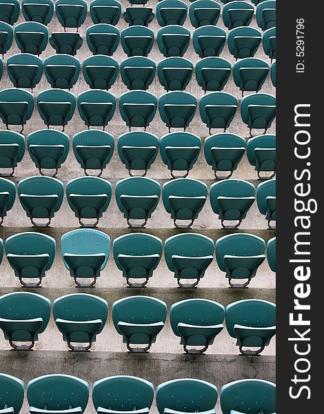 Empty Seating at Sports Stadium with Green Chairs