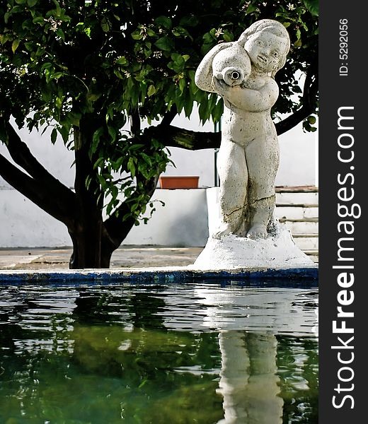 Fountain statue with pond and lemon tree .