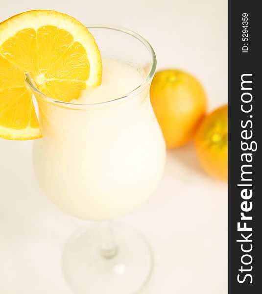 White pina colada with sliced orange, shot on white table cloth. White pina colada with sliced orange, shot on white table cloth