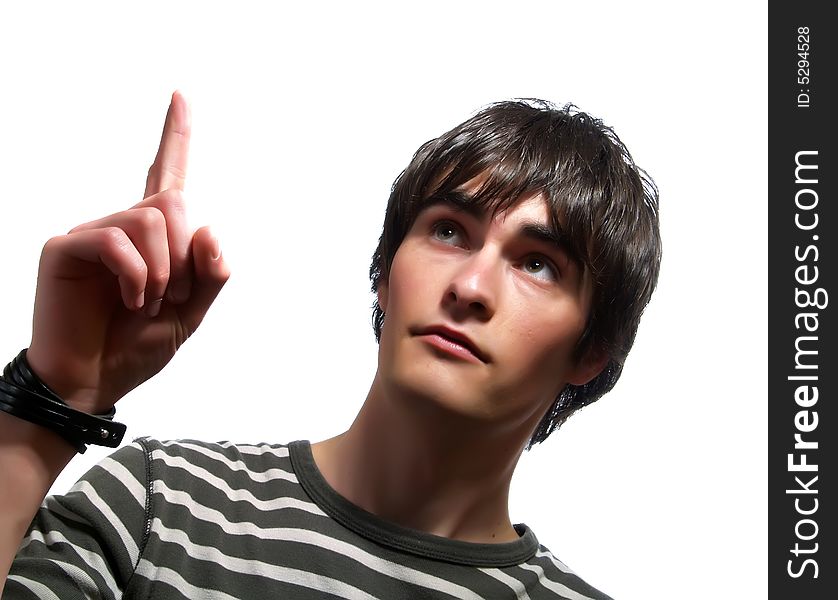 A portrait about a trendy cute young man who is smiling and he is showing upwards with his index finger. He is wearing a striped t-shirt. A portrait about a trendy cute young man who is smiling and he is showing upwards with his index finger. He is wearing a striped t-shirt.