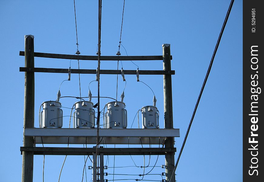 Electric transformers against blue sky