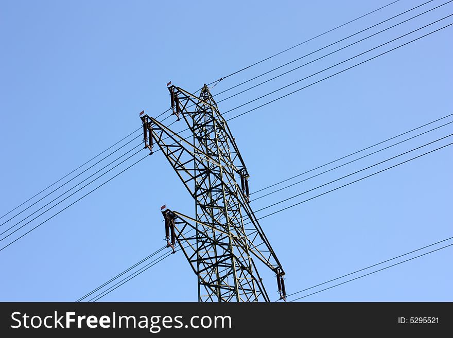 High voltage power line with a blue sky.