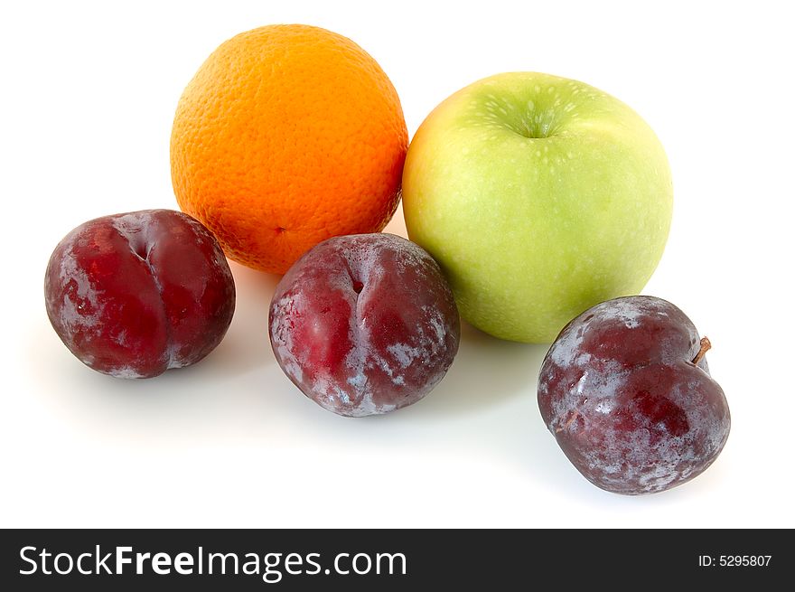 Apple, orange and  three lilac  plums on overwhite background. Apple, orange and  three lilac  plums on overwhite background.