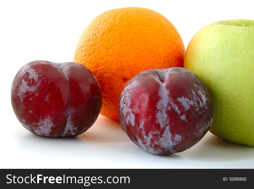 Apple, orange and lilac  plums on overwhite background. Apple, orange and lilac  plums on overwhite background.