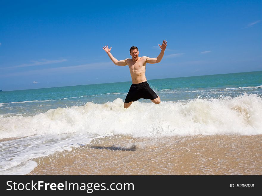 Caucasian Hunk Jumping Joyfully At The Beach