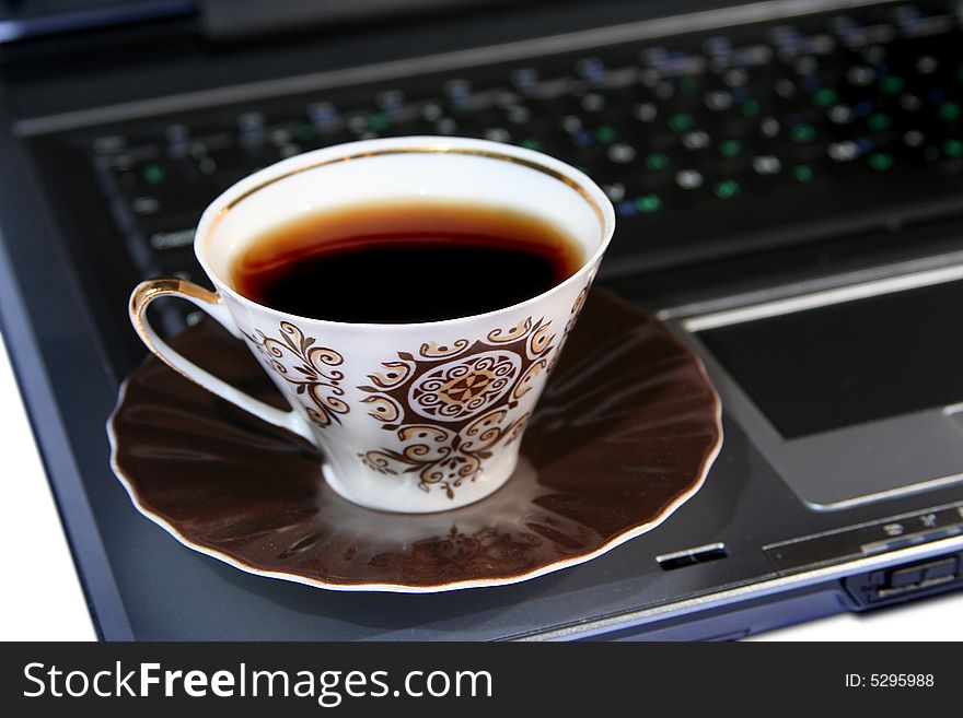 Cap of coffee on laptop